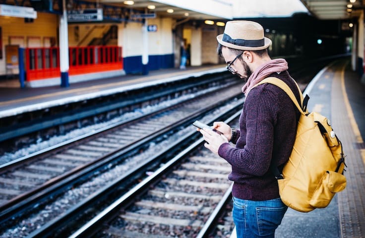 Man on his phone on a train platform