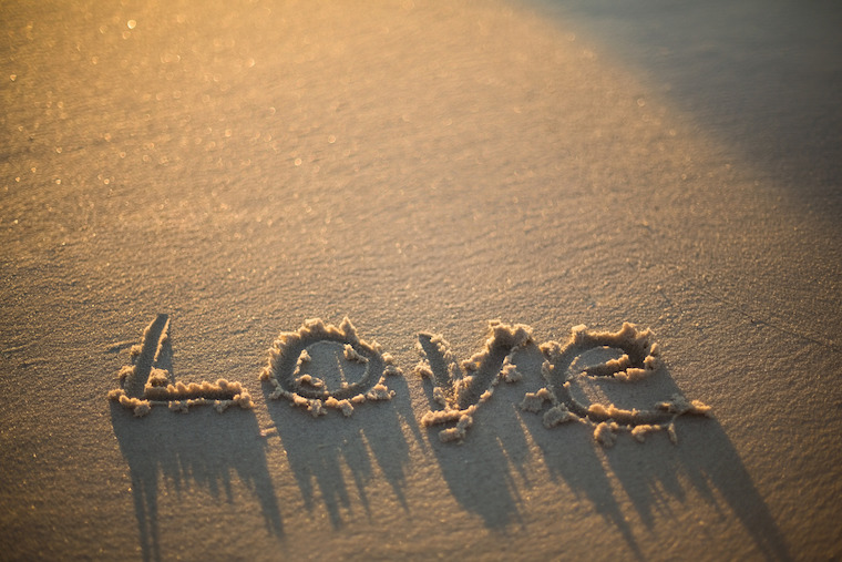 The word 'Love' written in the sand