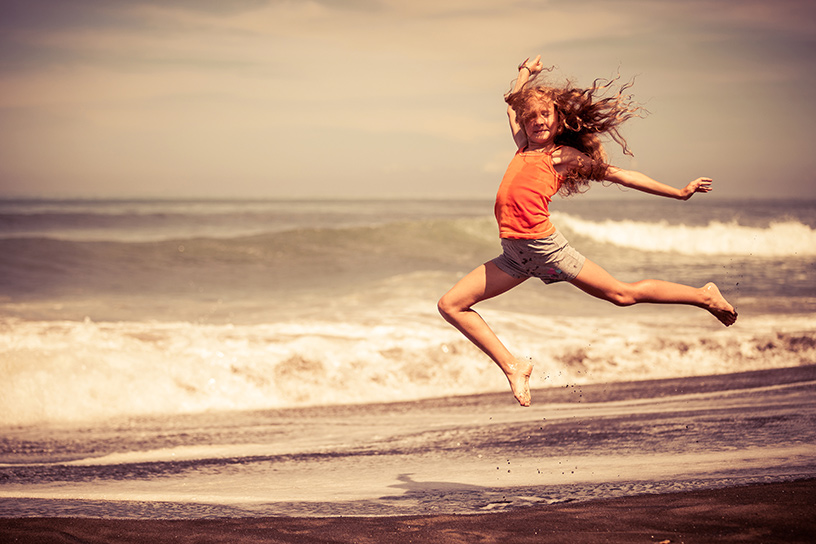 Teen Girl Jumping on Beach by altanaka