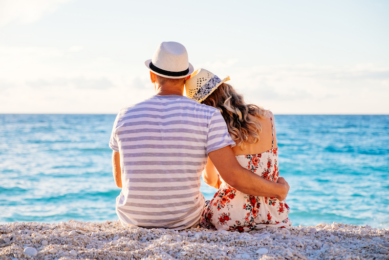 Couple sitting closely together on the beach