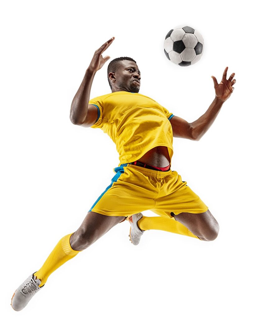 Professional african american football soccer player in motion isolated on white studio background. Fit jumping man in action, jump, movement at game.