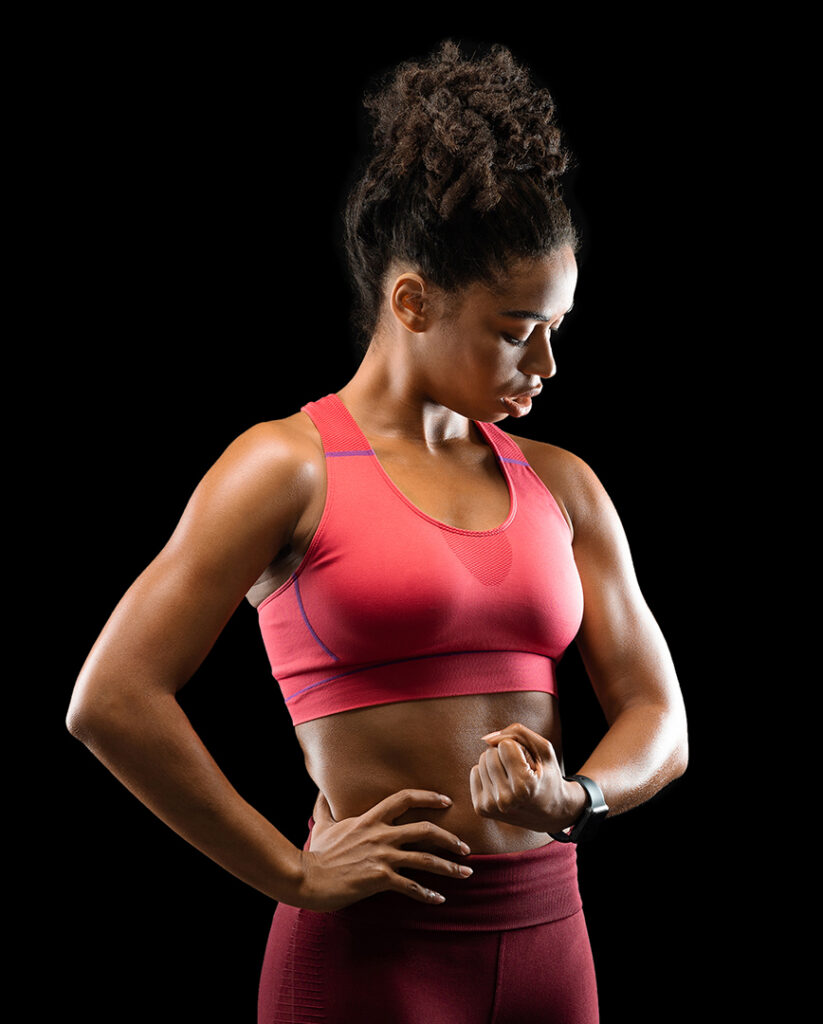 Afro woman bodybuilder showing her muscular biceps by Prostock-studio