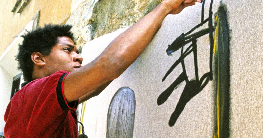 Jean-Michel Basquiat doing street art on a concrete wall