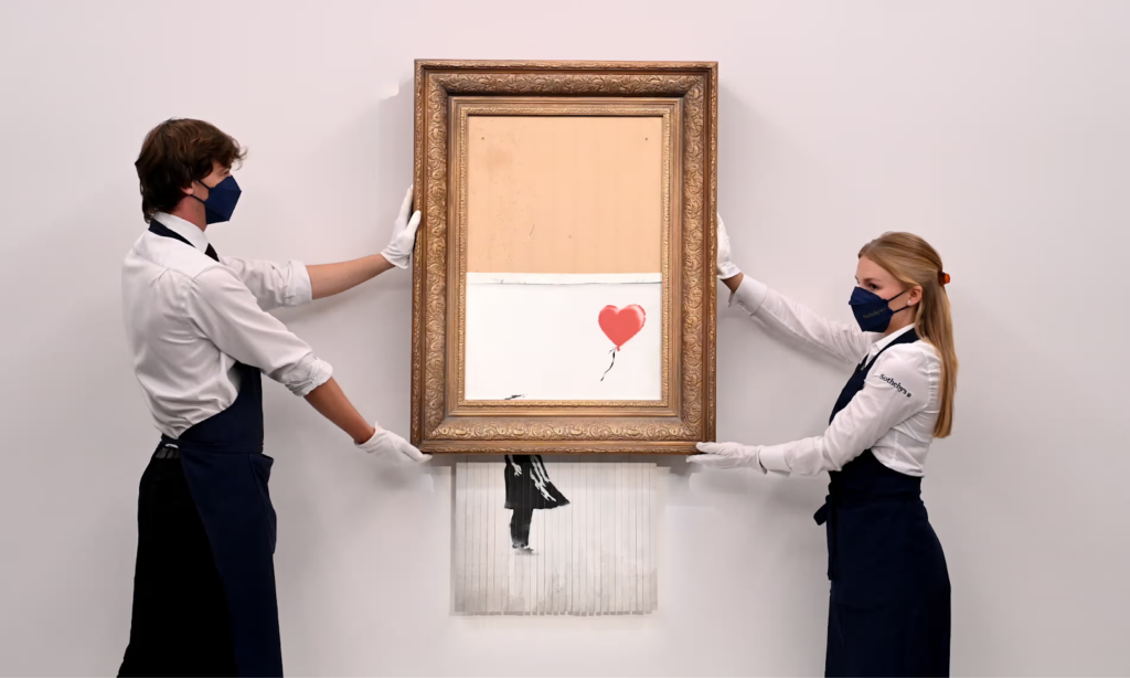 Banksy's "girl with balloon" artwork shredding itself after purchase