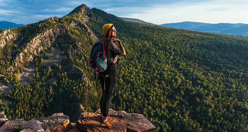 A traveler meets the sunset in the mountains. Hiking in the mountains
